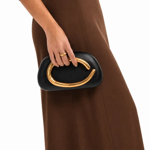 Black pillow clutch with sculptural gold ring handle