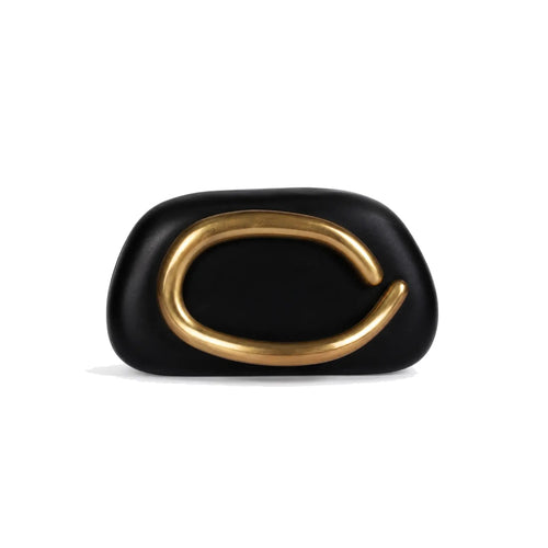 Black pillow clutch with sculptural gold ring handle