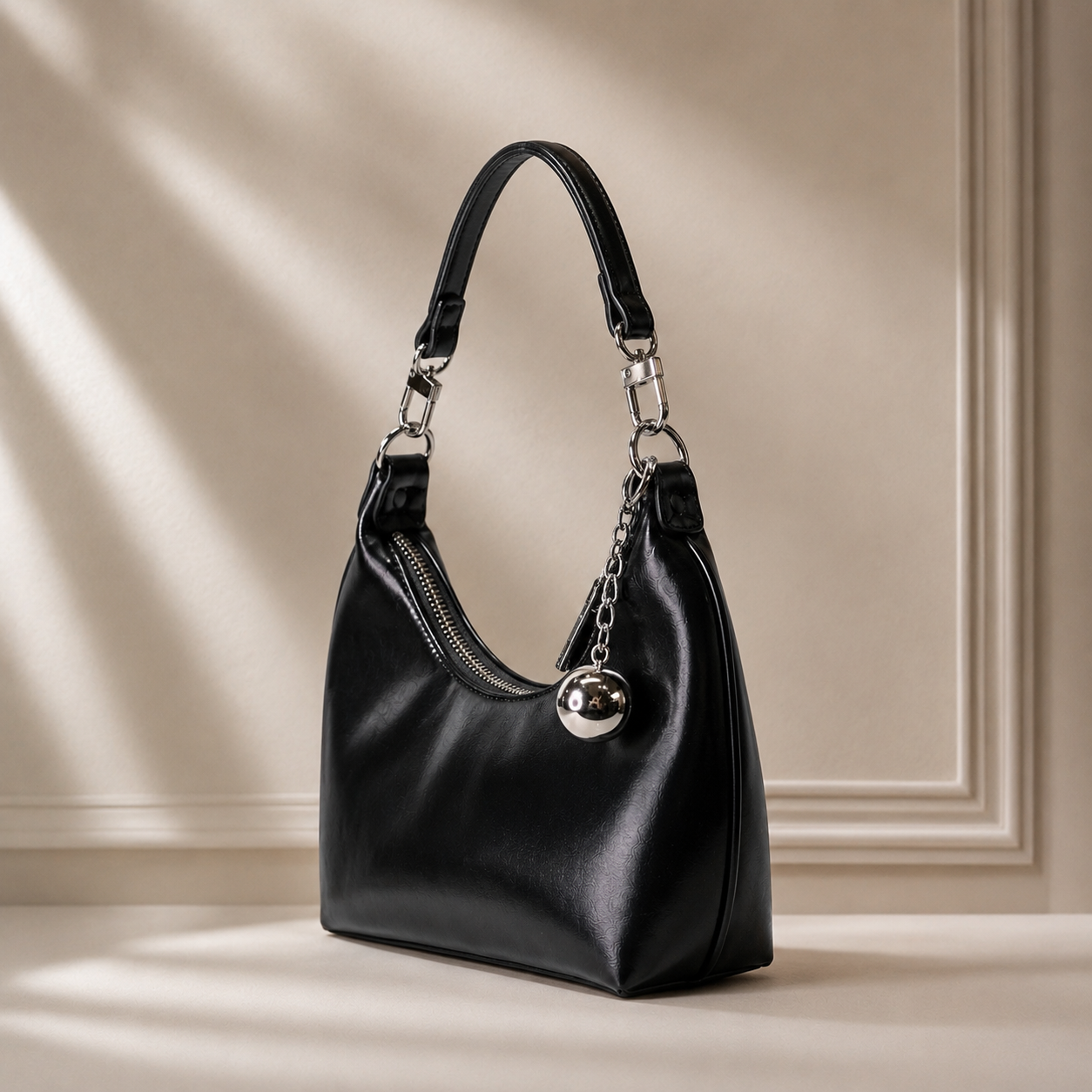 Black vegan leather curved hobo bag with silver orb charm and chain strap