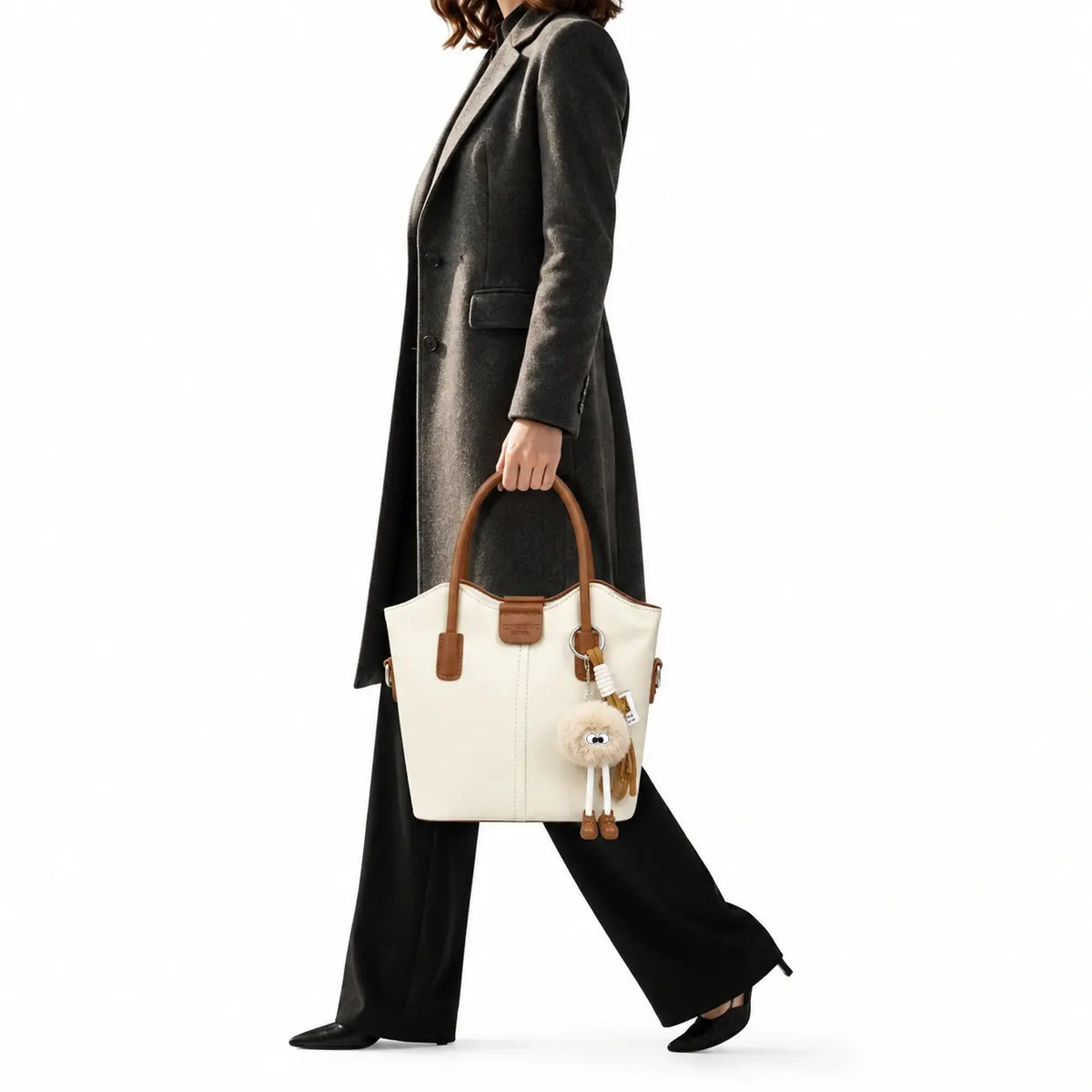 Ivory bucket tote bag with tan trim and pom-pom charm
