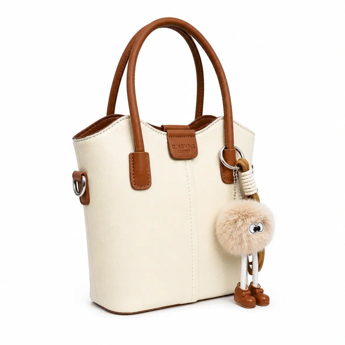 Ivory bucket tote bag with tan trim and pom-pom charm